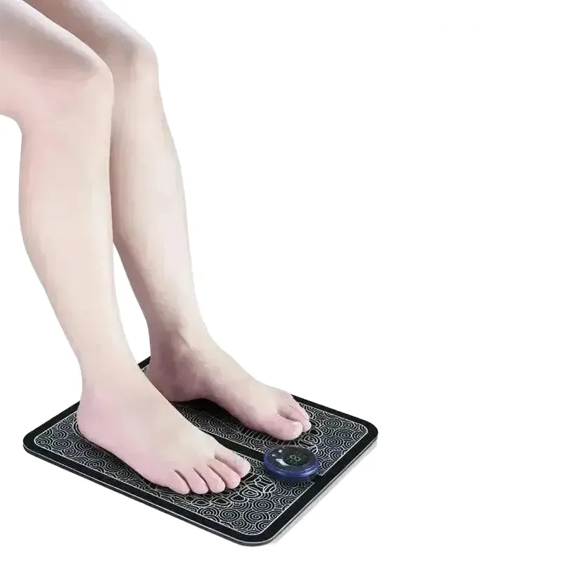 Feet on a rechargeable EMS foot massager pad with control dial, showing features like acupoint capture and USB charging.